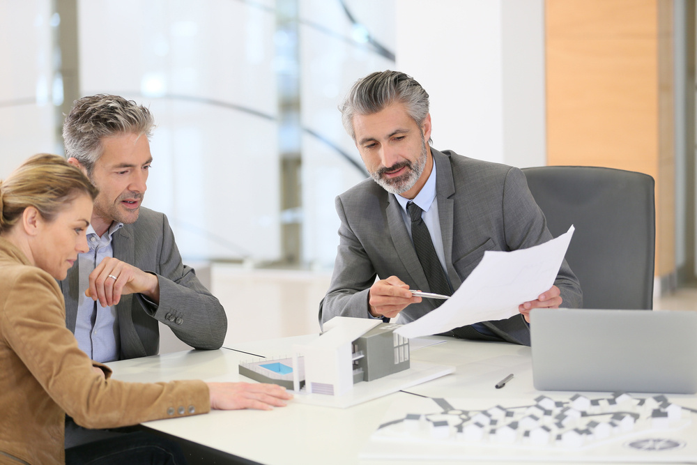 Mature couple meeting architect for construction project Mature couple meeting architect for construction project